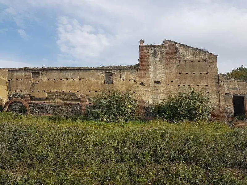 Edificio antiguo de ladrillo en ruinas rodeado de hierba